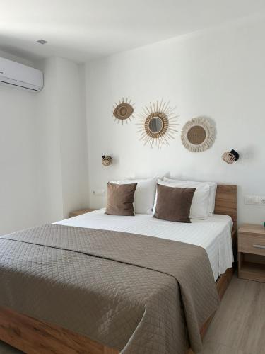 a bedroom with a large bed with two mirrors on the wall at Fiosal Apartments 3 in Skiathos