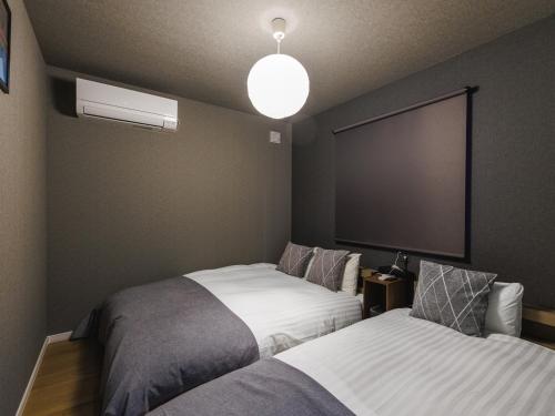 a bedroom with two beds and a large screen at tonaResort Furano in Furano