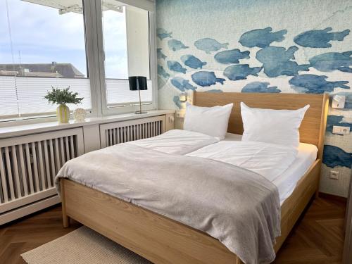 a bedroom with a bed with a blue and white wall at Boje in Westerland