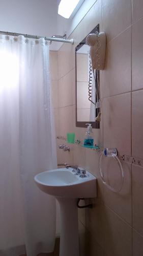 a bathroom with a sink and a shower curtain at Cabañas Llajta Sumaj in Las Calles