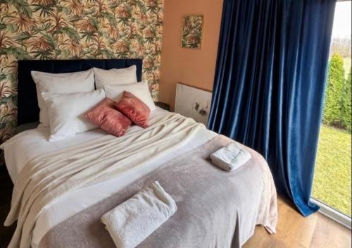 a bedroom with a bed with pillows and a window at Domki La Bella 3 in Aleksandria