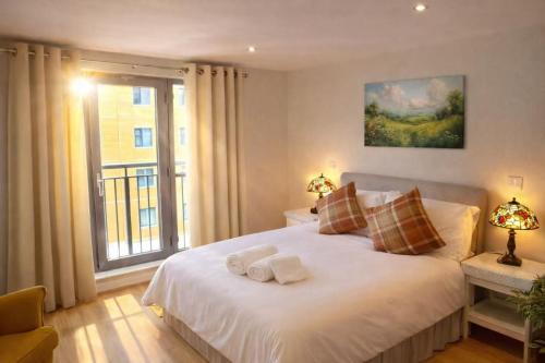 a bedroom with a large white bed with a window at New,London Hideaway Studio in Woking