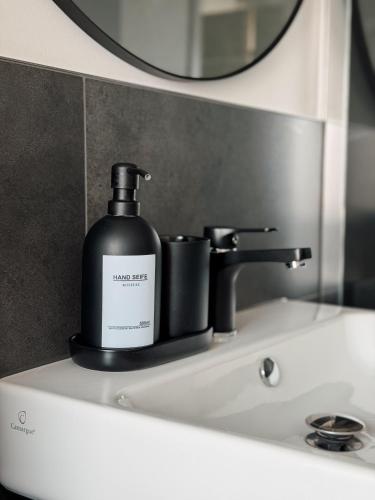 a bottle of soap sitting on top of a bathroom sink at MiDaMi 24h Hotel Self-Checkin in Schwanau