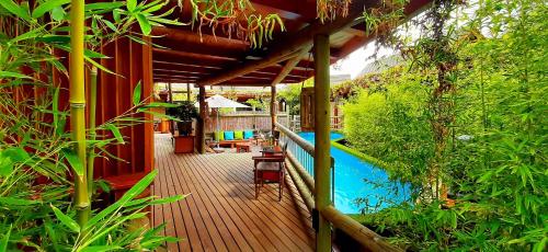 a house with a wooden deck next to a swimming pool at Paradise Private Zen Studios in Knysna