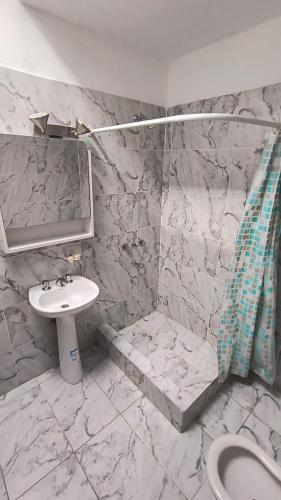a marble bathroom with a sink and a shower at Casa Celina in La Falda
