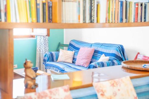 a living room with a blue couch with pillows at Domu de Zita in Poggio
