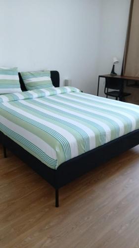 a bed in a bedroom with a striped mattress at Chic 2 chambres appartement proche de Paris in Vitry-sur-Seine