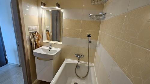 a bathroom with a sink and a toilet and a tub at Apartmán Orchidea in Prešov