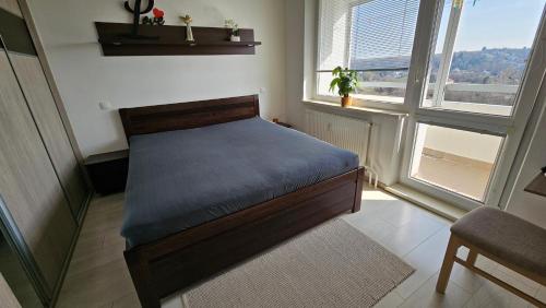 a bedroom with a bed in a room with windows at Apartmán Orchidea in Prešov