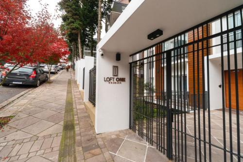 a building with a gate on the side of a street at Stay Home Luxo Gramado - 1 min da rua Coberta - Tudo a pé - Apartamentos Decorados - Varanda - Ar condicionado quente e frio - Roupas de cama Premium in Gramado