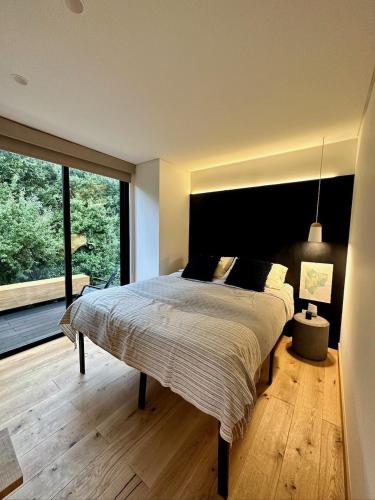a bedroom with a large bed with a large window at Camp Cold Springs in Concan