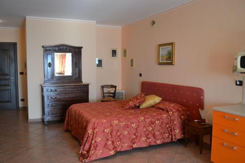 a bedroom with a bed and a dresser and a television at Alisea Eco Residence in Pocapaglia