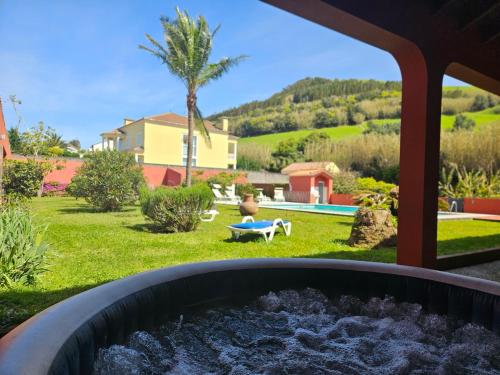 a garden with a fire pit in the yard at A Casa do Comandante - Piscina e Jardim in Lagoa