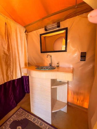 a bathroom with a sink and a mirror in a room at Elite Sahara Desert Camp in Merzouga