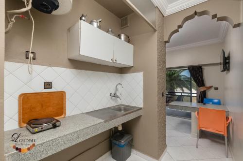 a kitchen with a sink and a counter at Hôtel Résidence Louban in Agadir