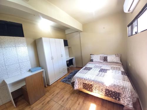 a bedroom with a bed and a desk and a window at Colman Apart Central in Ciudad del Este
