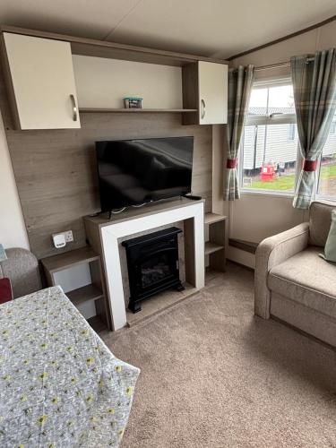a living room with a television and a fireplace at Oakley caravan rental in Skegness
