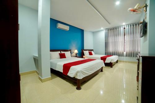 a bedroom with two beds and a blue wall at Stargazer Hotel in Danang