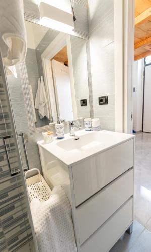 a white bathroom with a sink and a mirror at Sto bene al mare in Termoli