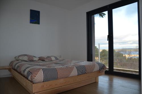 a bed in a room with a large window at à la cime du mont Saint Clair in Sète