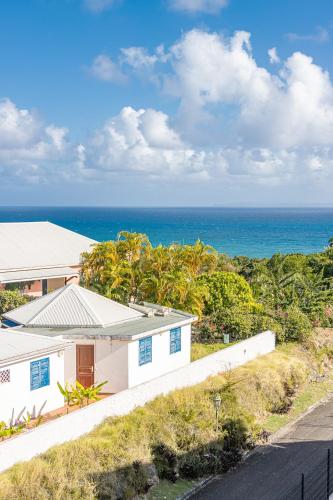 Ein weißes Haus mit dem Meer im Hintergrund in der Unterkunft Mare Gaillard in Le Gosier