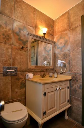 a bathroom with a toilet and a sink and a mirror at Fikretbey Konağı in Ayvalık