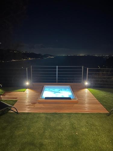 a deck with a swimming pool at night at Villa dei Roveri in Tignale