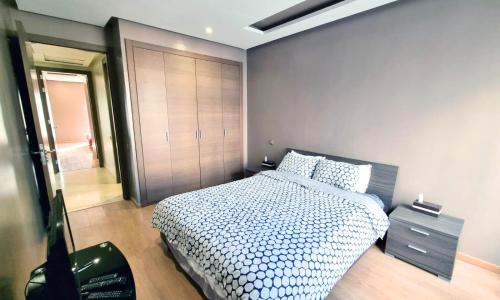 a bedroom with a large bed and a closet at Agréable appartement familial avec Piscine - City Center in Fez