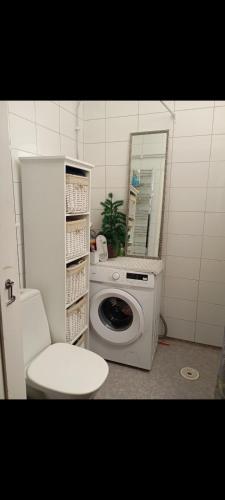 a bathroom with a washing machine and a mirror at Karlskrona centrum in Karlskrona