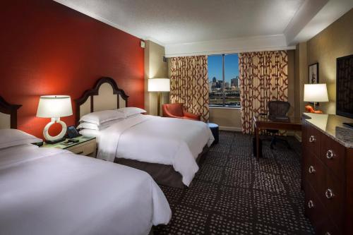 a hotel room with two beds and a window at Hilton Anatole in Dallas