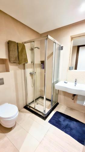 a bathroom with a shower and a toilet and a sink at Agréable appartement familial avec Piscine - City Center in Fez
