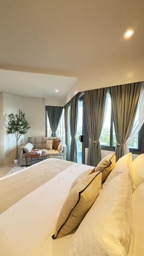 a large white bed with pillows in a bedroom at 12th Floor Studio Tambuli, Sea View, Balcony in Maribago
