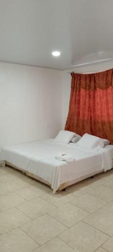 a bedroom with two beds and a red curtain at Apartamento INRU in Puerto Cortés