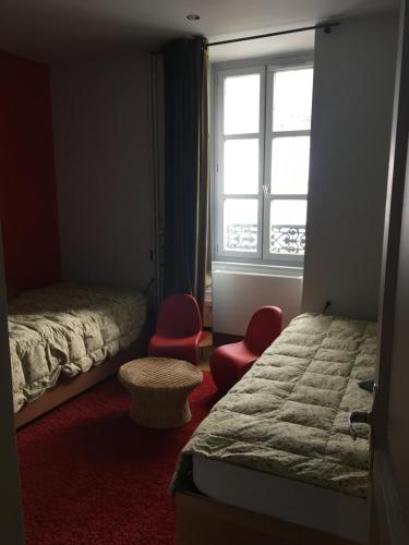 シャモニー・モンブランにあるAppartamento Vittoriaのベッドルーム1室(ベッド2台、窓、赤い椅子付)