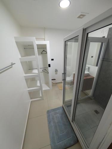 a bathroom with a glass shower and a blue rug at Hotel & Plaza San Blas in Comayagua