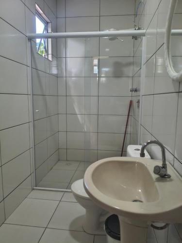 a white bathroom with a sink and a toilet at Pousada Esperança - Areias SP in Areias