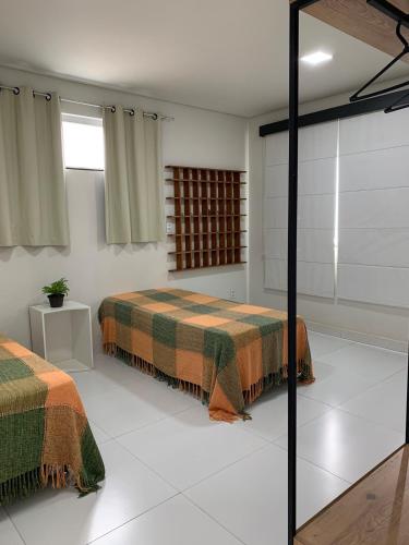 a bedroom with two beds and a glass wall at Apartamento do Sol in Diamantina