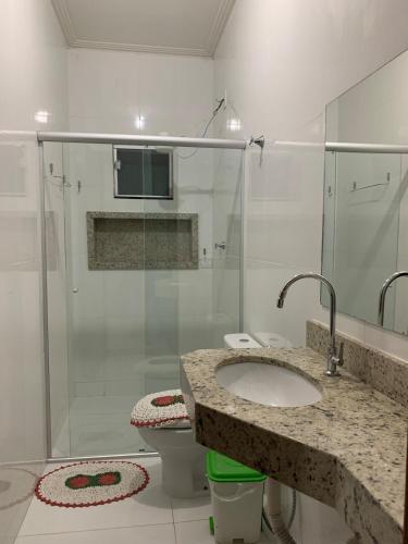 a bathroom with a shower and a sink and a toilet at Apartamento do Sol in Diamantina