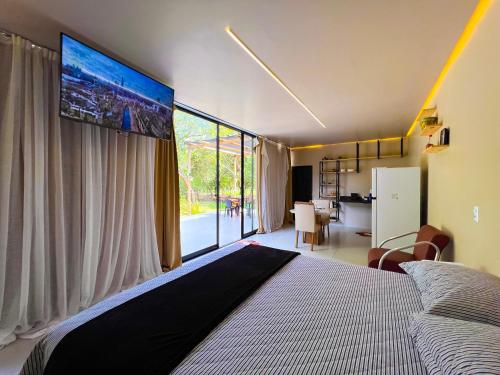 a bedroom with a large bed with a large window at Bosque dos Buritis in Araguaína