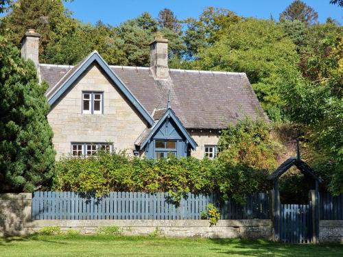 a house with a blue fence in front of it at Midhope Castle Cottages in Queensferry