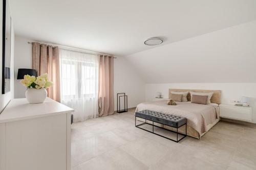 a white bedroom with a bed and a window at Luxury Apartment Marz in Schwanau