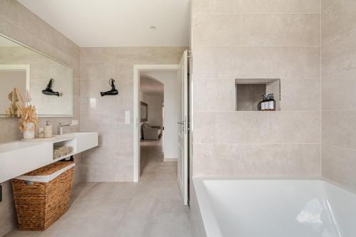 a white bathroom with a tub and a sink at Luxury Apartment Marz in Schwanau