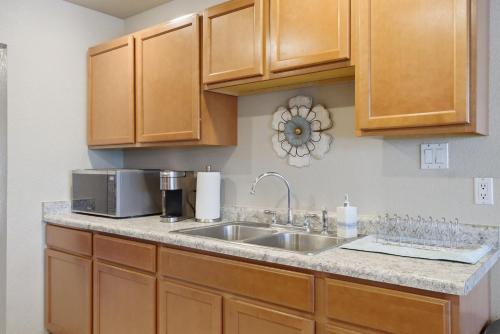 a kitchen with a sink and a microwave at Private Beach Volleyball Pool Retreat in Las Cruces