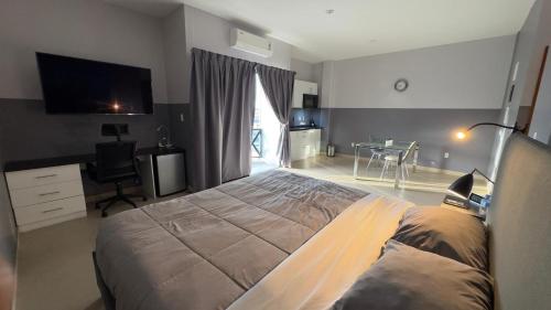 a bedroom with a large bed and a television at RC Apartments Suriname in Paramaribo