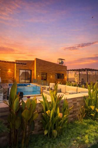 a home with a swimming pool and a house at اكواخ الغصن الريفيه in Jeddah