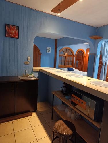 a room with a bed and a sink and a kitchen at Casa Maya Vibes in Santiago Atitlán