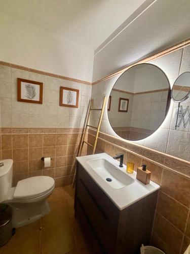 a bathroom with a sink and a toilet and a mirror at Casa D' Oliveira in Castro Verde