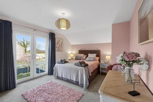 a bedroom with a bed and a large window at 3 Bed in Brynteg oc-d33659 in Brynteg