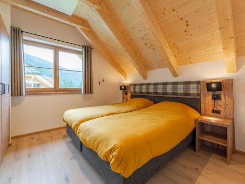 a bedroom with a large bed with yellow sheets at Haus Rapunzel in Donnersbachwald