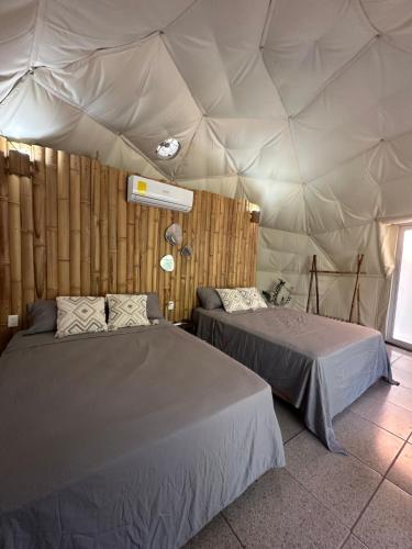 a room with two beds in a tent at Bambuk Bio Dome Uvita beach front in Uvita